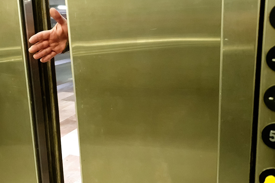 man's hand in elevator doors