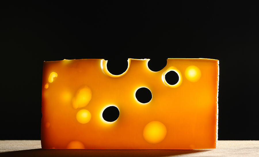 Swiss cheese over black background